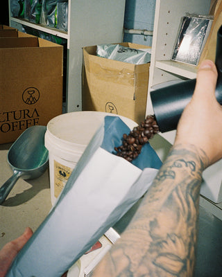 Altura Coffee beans being poured into a coffee bag 