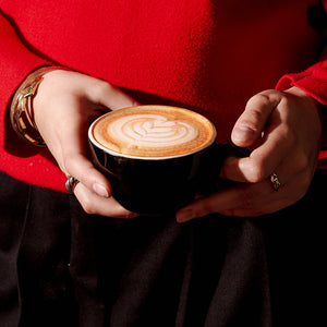 Barista holding an Altura Coffee Flat White 